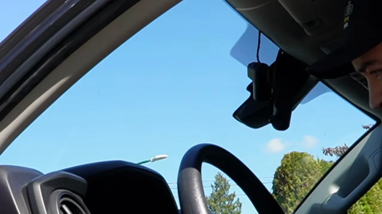 Front dash camera mounted behind mirror with interior camera above it