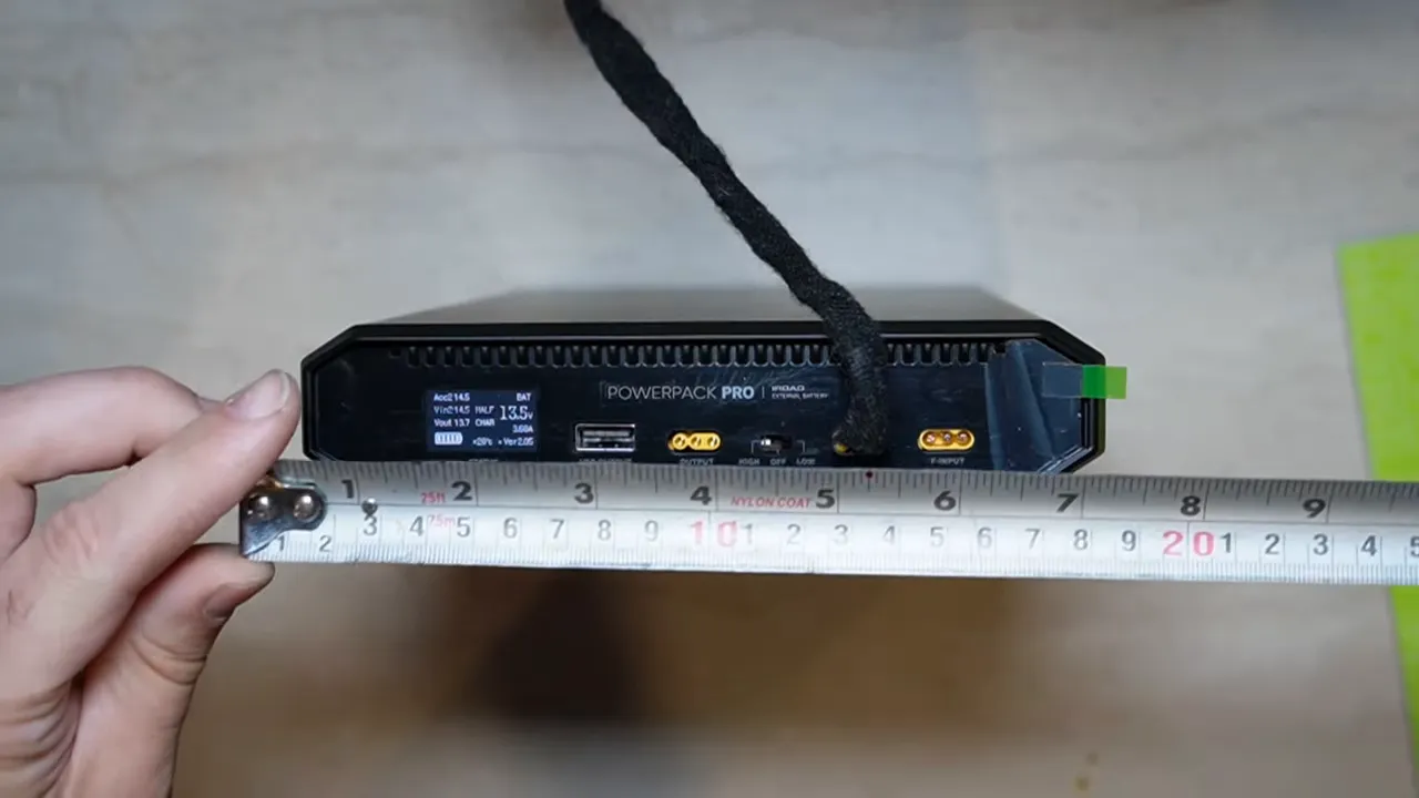 Measuring the iRoad Powerpack Pro 15 dash cam battery pack with a ruler along the side panel