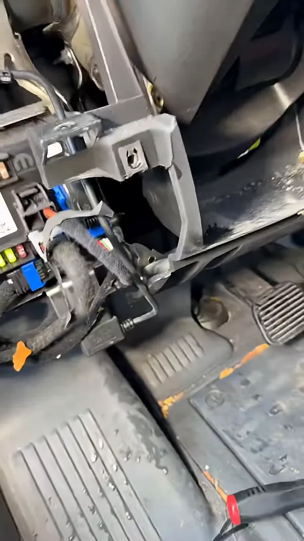 Messy under-dash GPS installation with exposed cables, connectors and footwell area