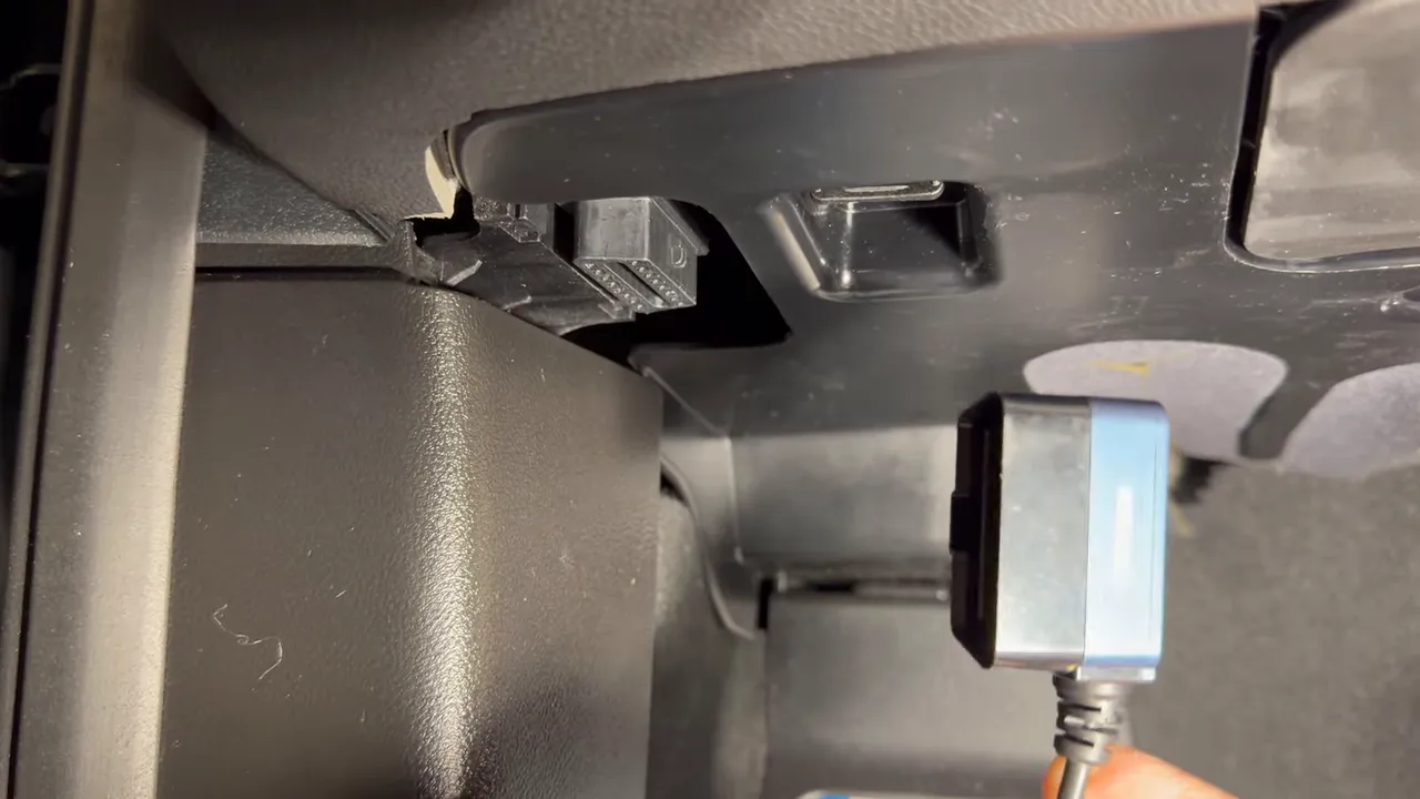 OBD2 power adapter positioned under dash ready to plug in