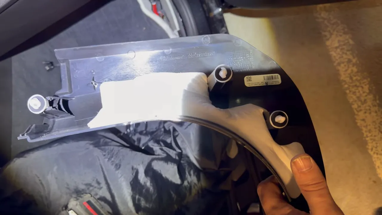 kick panel trim with clip posts and foam backing held by hand