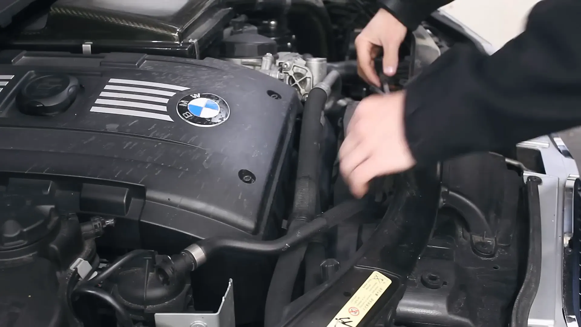 Installing the new coolant hose in the BMW