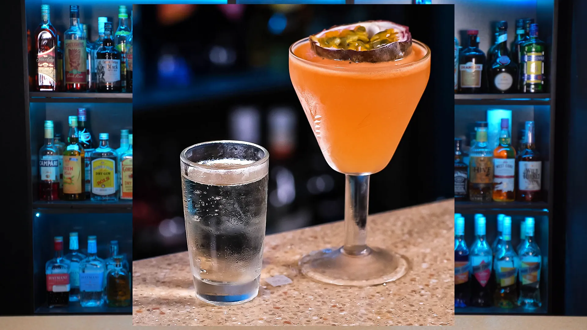 Pornstar Martini într-un pahar de cocktail, garnisit cu jumătate de fruct pasiunii