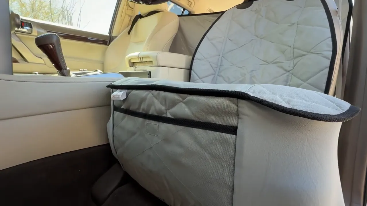 Gray quilted front bucket seat cover with a black-trimmed storage pocket on the seat front