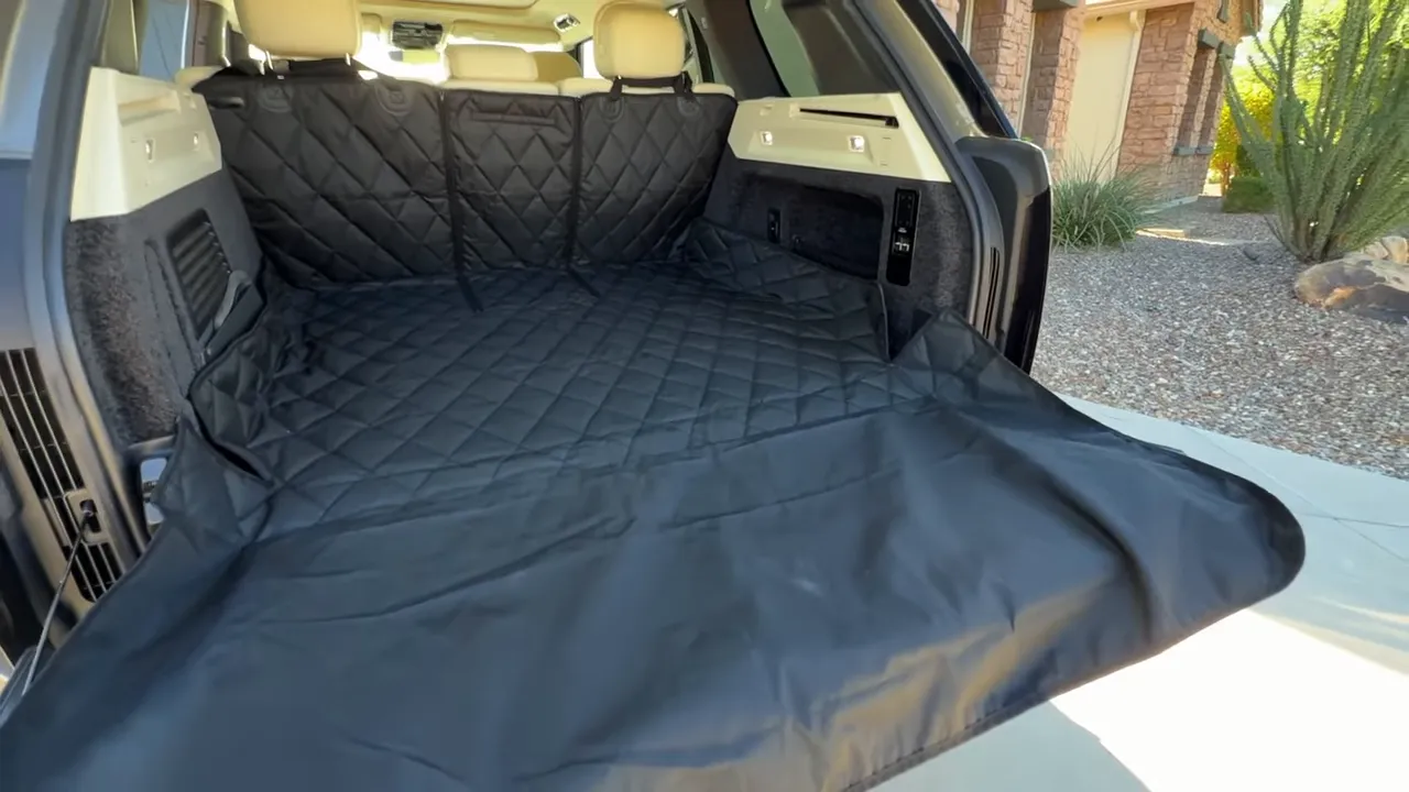 Range Rover cargo area with a black quilted liner and bumper flap extended over the rear bumper