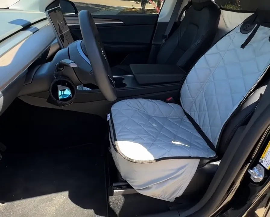 Quilted front bucket seat cover installed on the Tesla Model Y driver seat