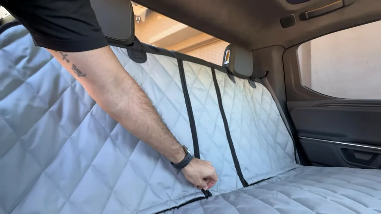 Close view of two black zippers running down the center of the gray rear seat cover
