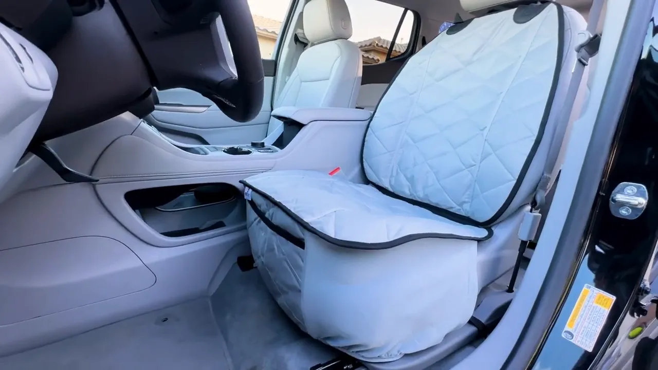 Gray quilted universal front seat cover installed on the driver seat of a GMC Acadia