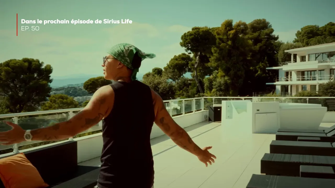 Personne bras ouverts sur une terrasse avec vue sur des arbres et la mer au loin, ambiance contemplative