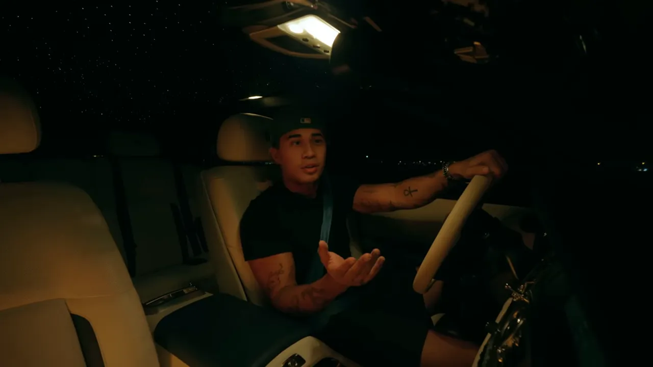 Auteur en voiture la nuit, main en geste explicatif en racontant le pari NFT