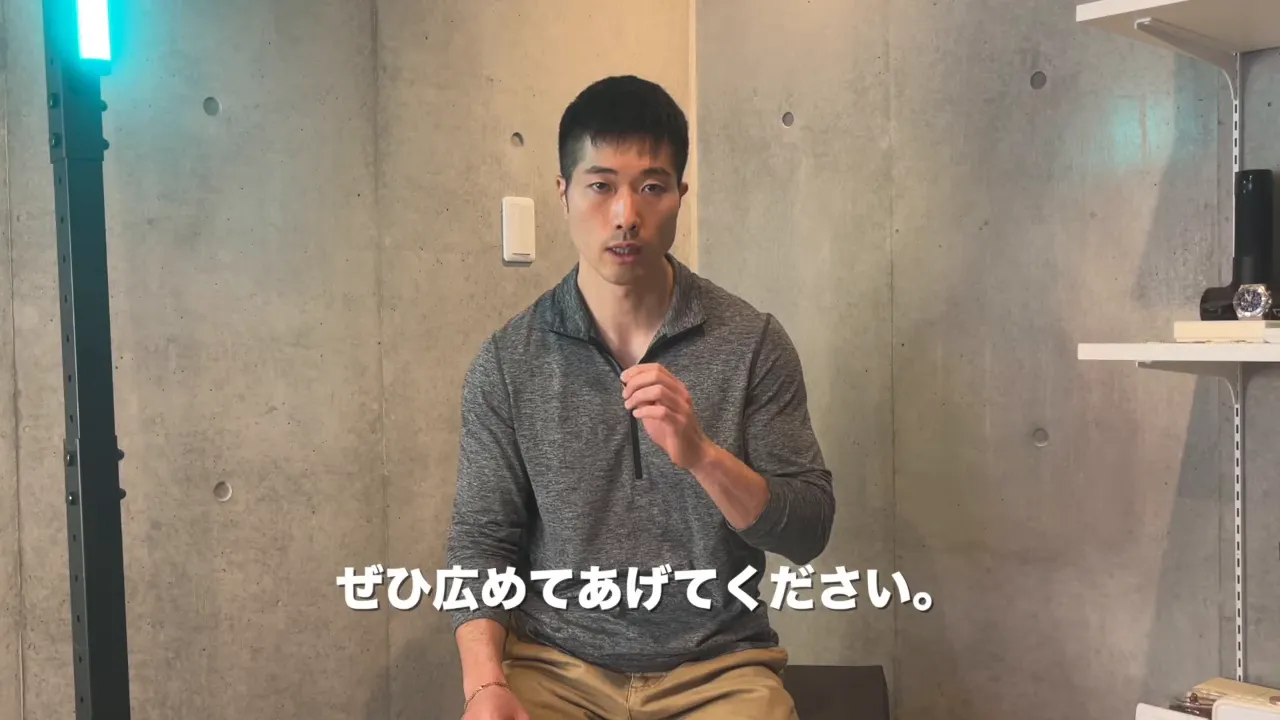 カメラ目線で話す男性のクローズアップ(字幕「ぜひ広めてあげてください。」)
