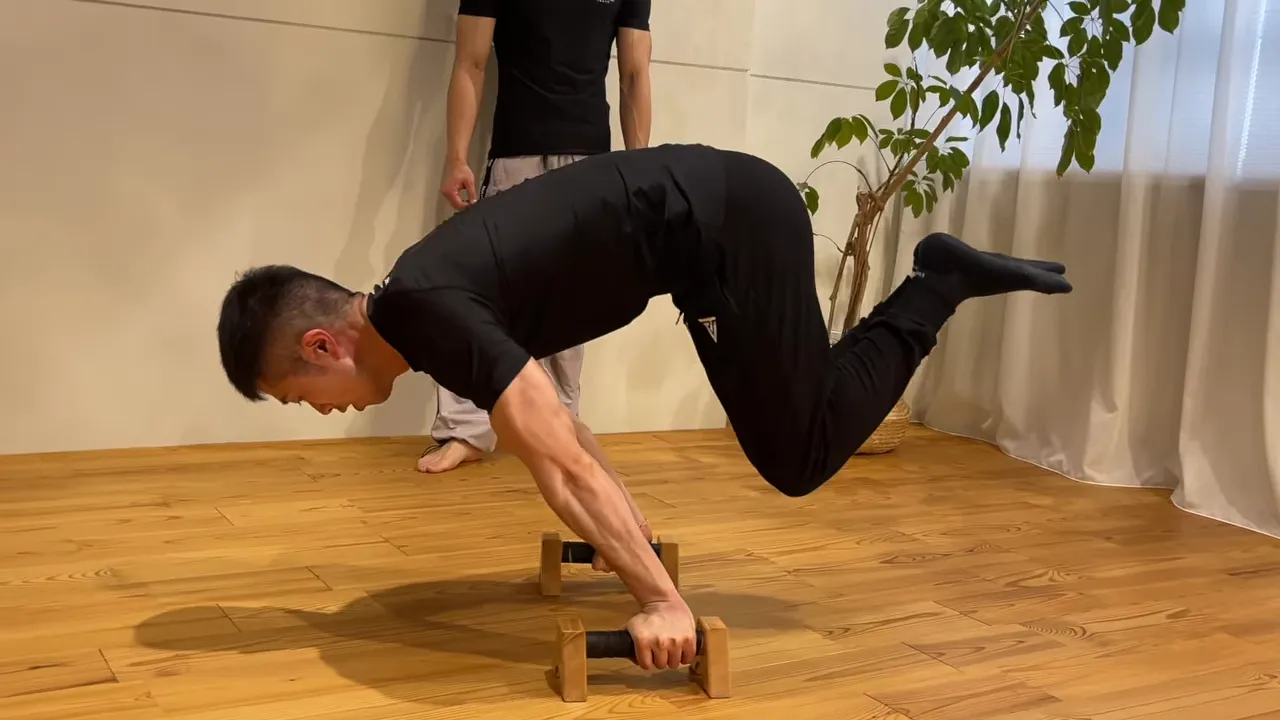 パラレット上で膝を後ろへ出したアドバンストタックプランシェ