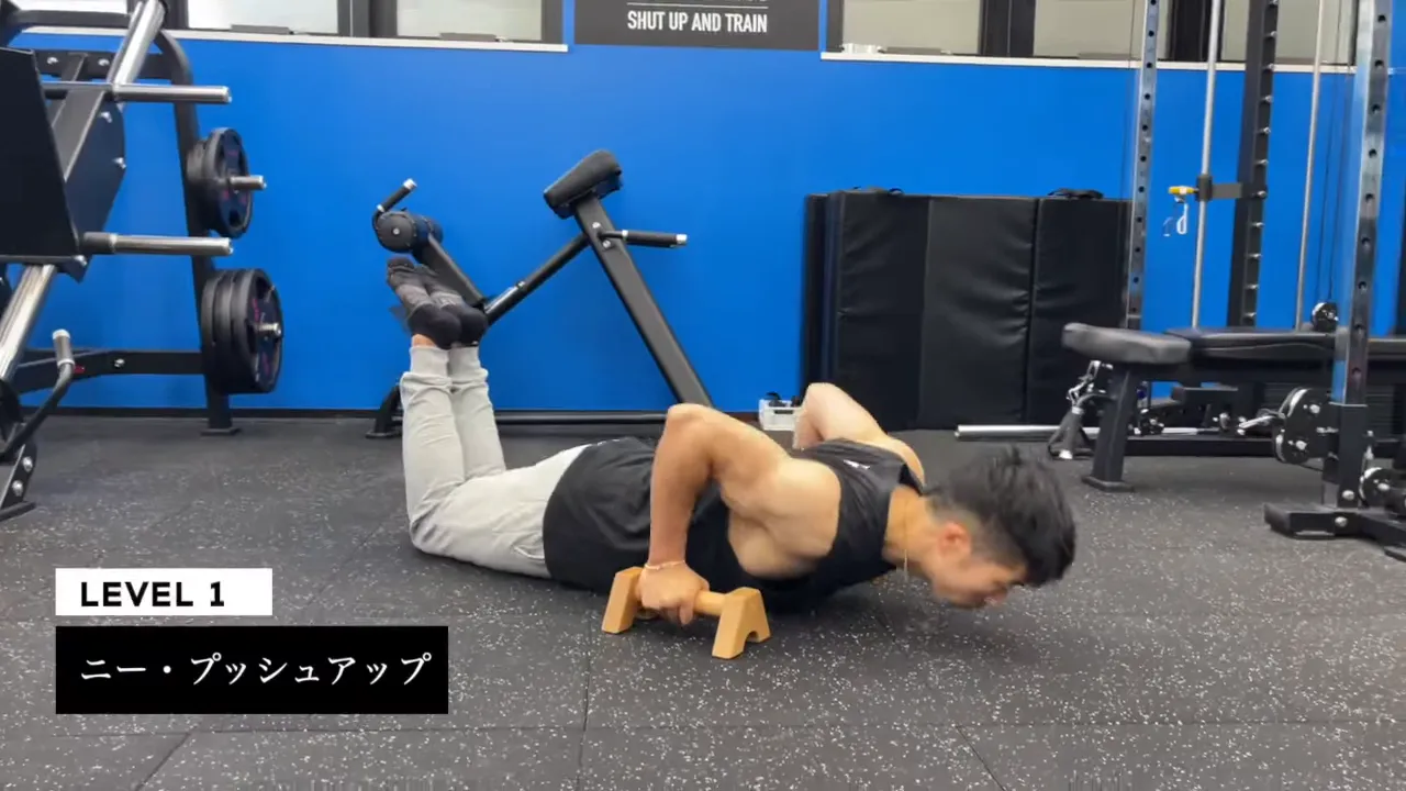 膝をついてプッシュアップバーで腕立て伏せをする男性とレベル1の表示