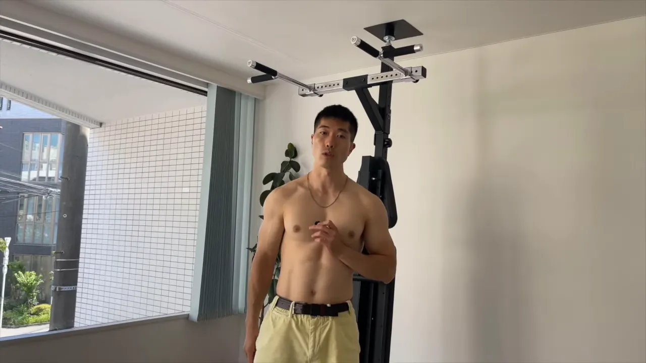 懸垂バー前でコア種目のフォームの重要性を説明するトレーナー