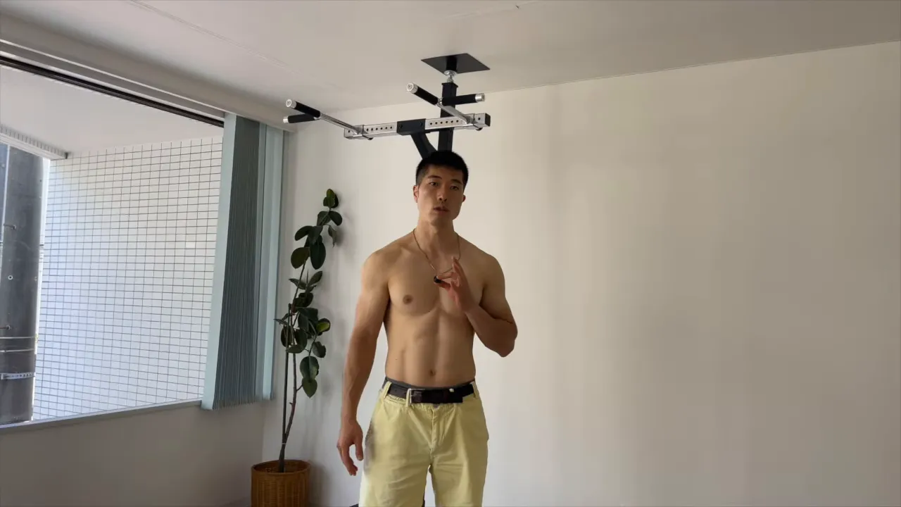 懸垂バーの前で説明する男性（ブルガリアンスクワットへの準備）