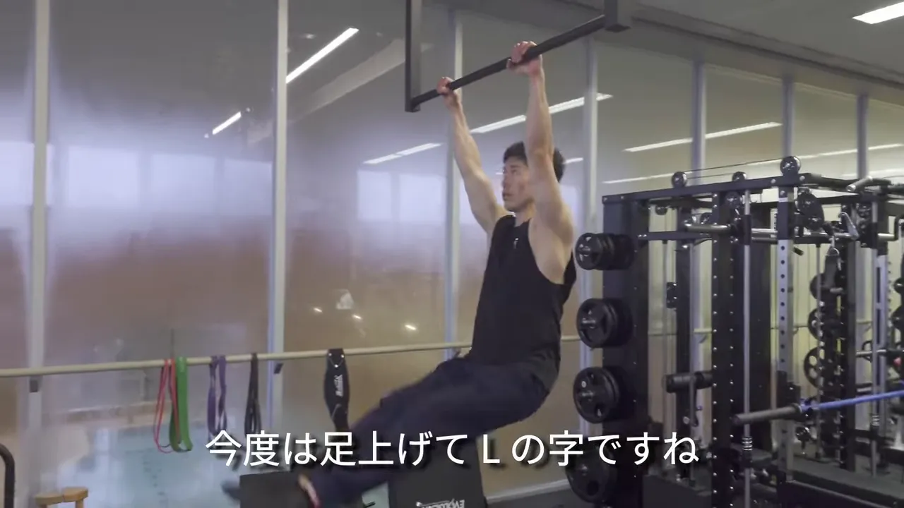 脚を前に上げたL字姿勢で鉄棒を引いているLプルアップ