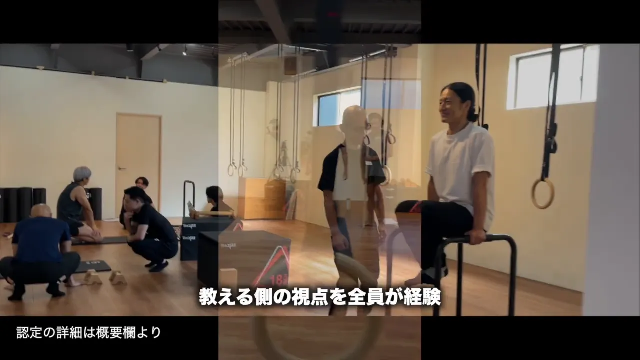 平行棒に座って膝を上げる受講者と隣に立つ受講者、奥で練習する参加者
