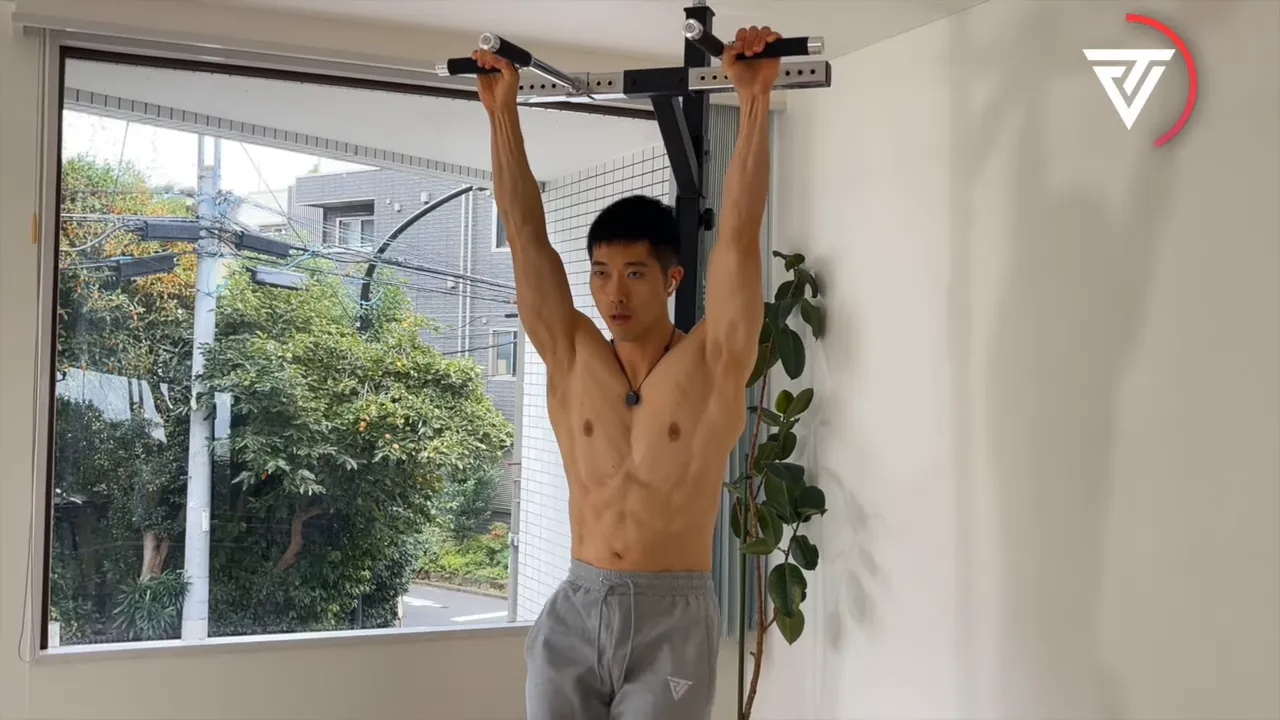 懸垂バーでハンギング種目のフォームを作る男性（上部で保持）