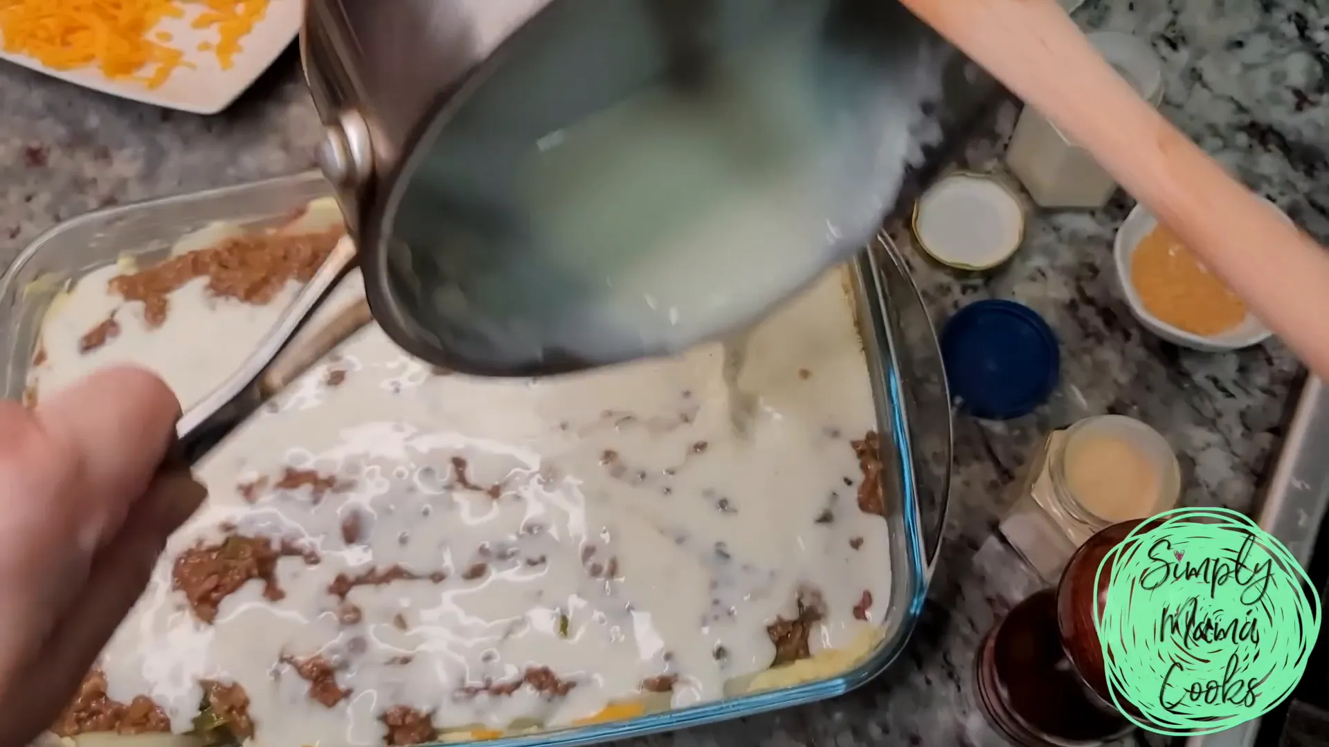 Adding béchamel sauce on top of the casserole