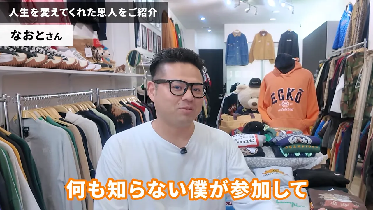 古着ショップの中央で穏やかに話す男性と棚やハンガーにかかった衣類