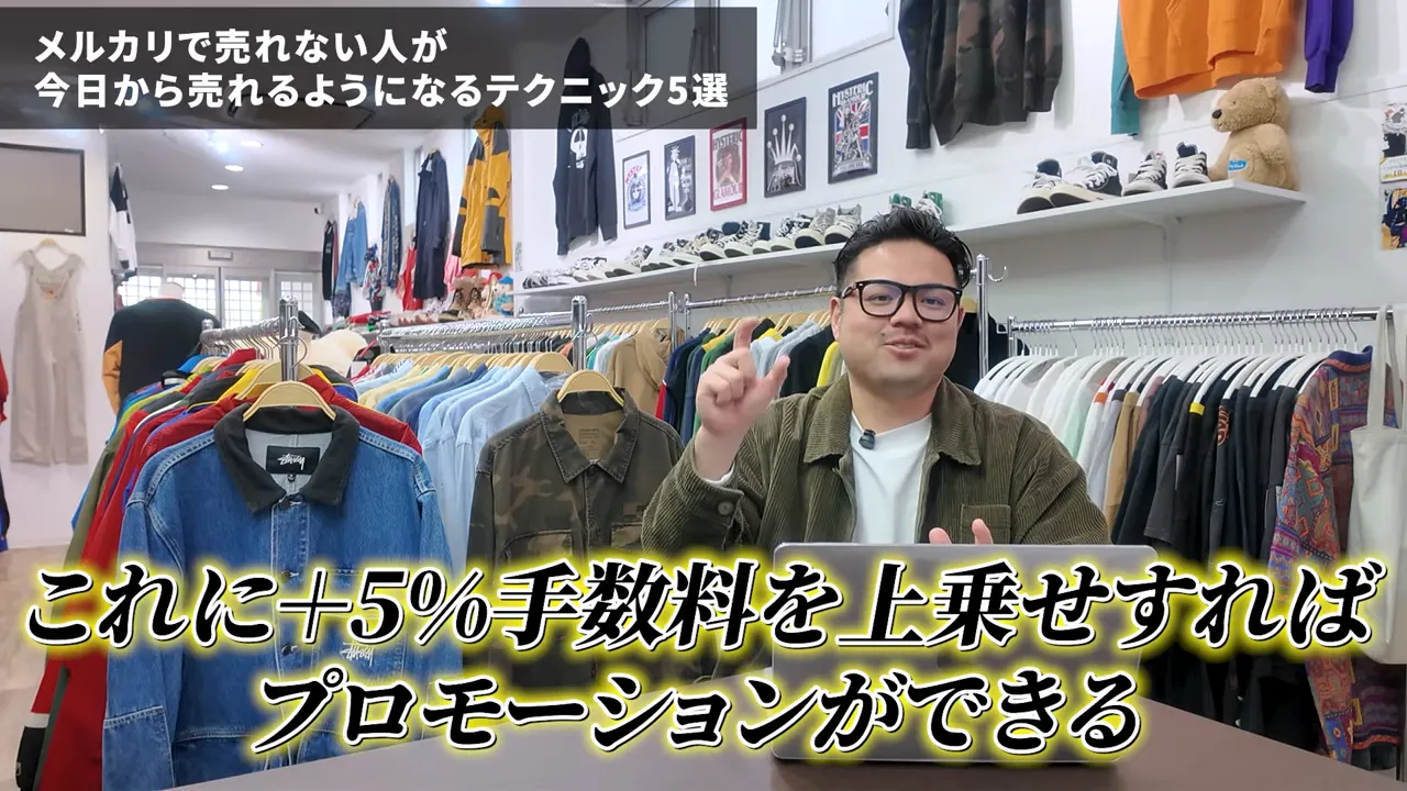 古着店の前でプロモーションに+5%の手数料を上乗せする説明をする講師と服のラック