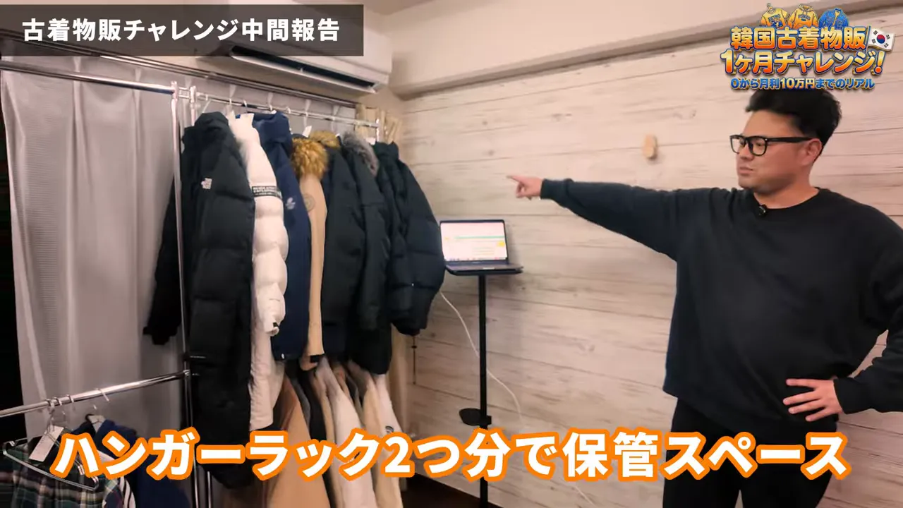 ハンガーラックにかかったコートと作業用のノートパソコンがある小さな部屋