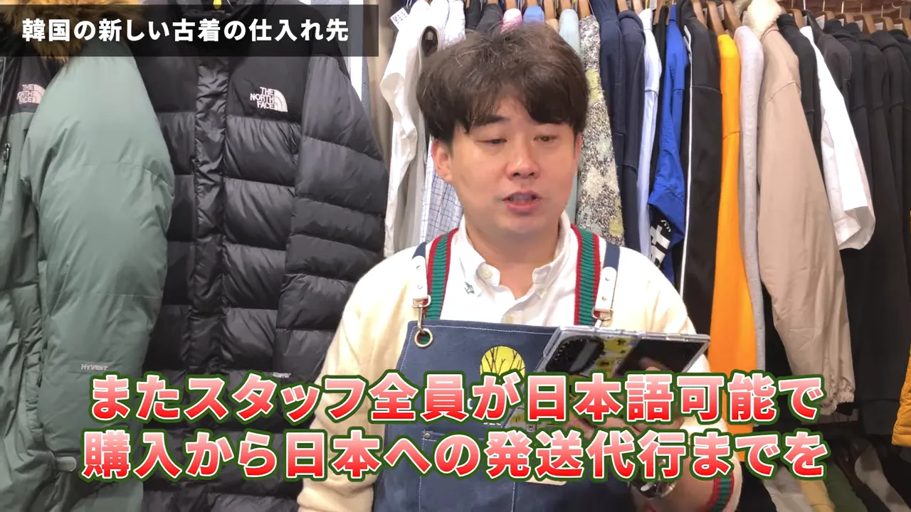 日本語対応について説明する現地スタッフと並ぶジャケット