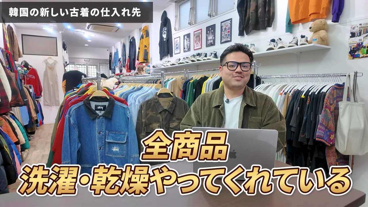 古着が並ぶ店内で説明する人物。画面下部に大きく『全商品 洗濯・乾燥やってくれている』というテロップが表示されている。