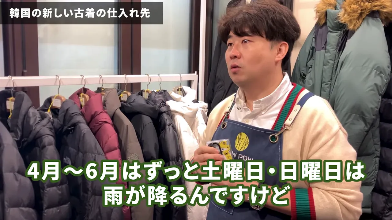 ハンガーにかかった多数のダウンジャケットと店員がいる店内の様子