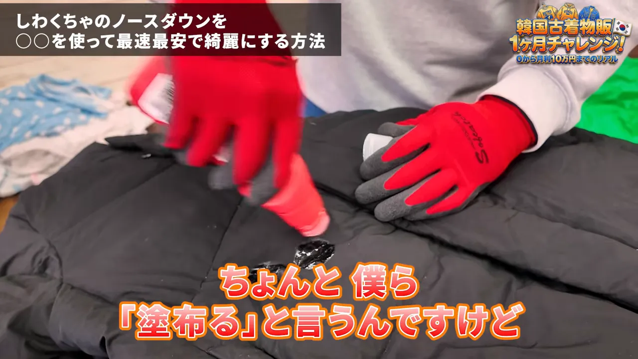 赤い手袋でダウンに洗剤を塗布している手元のアップ