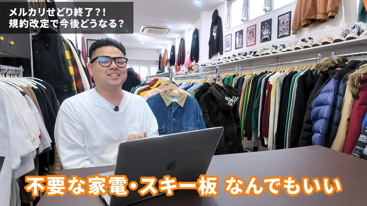 ノートPC前で不要品を混ぜた出品運用を説明する男性と洋服ラック
