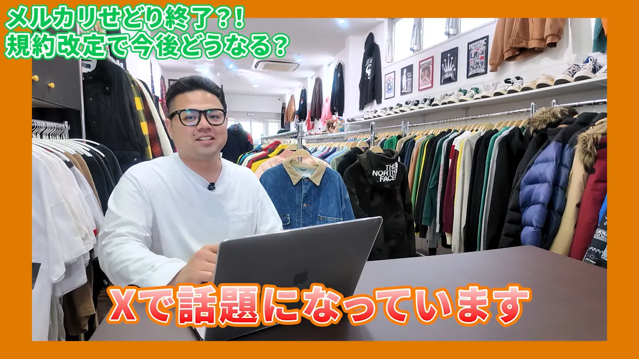 店内でノートパソコンを前に話す出品者と服のラック