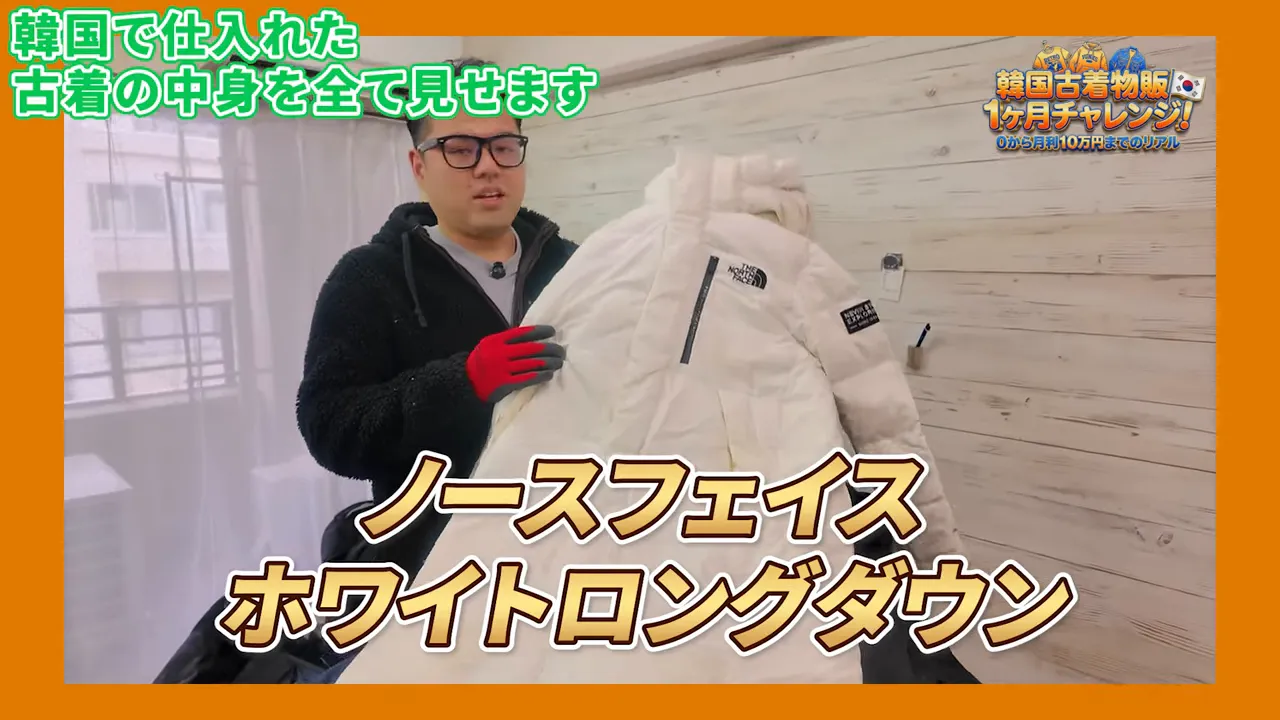 白いノースフェイスのロングダウンを手に持って見せる人物の写真