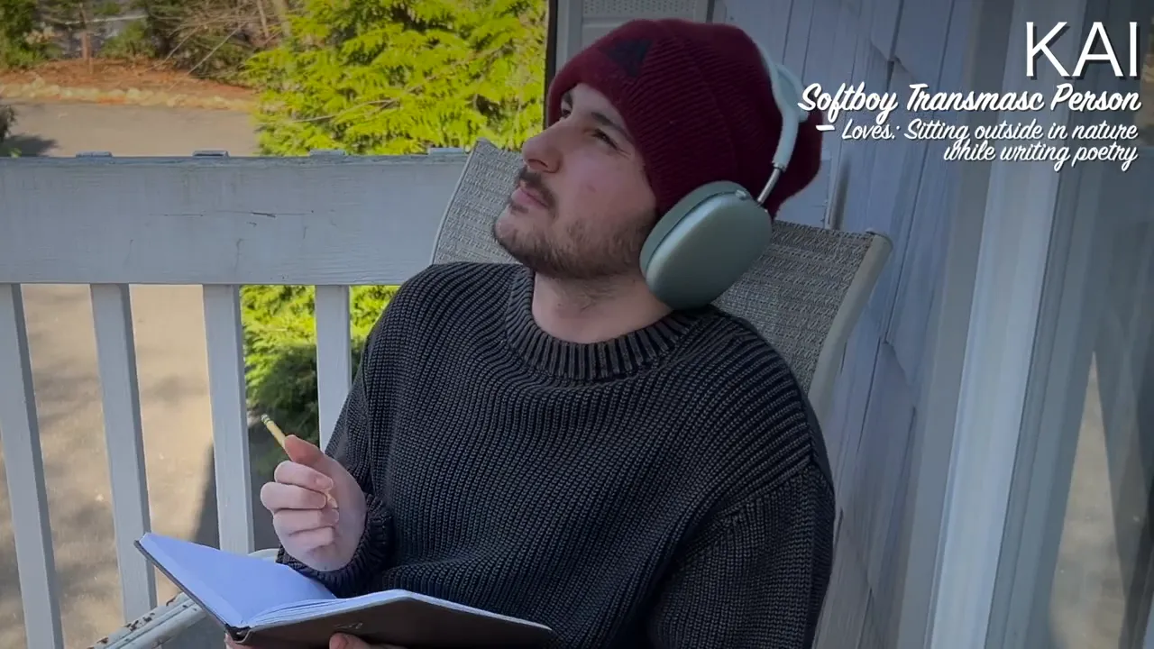 person in a beanie and headphones sitting on a porch with a notebook and pencil looking upward