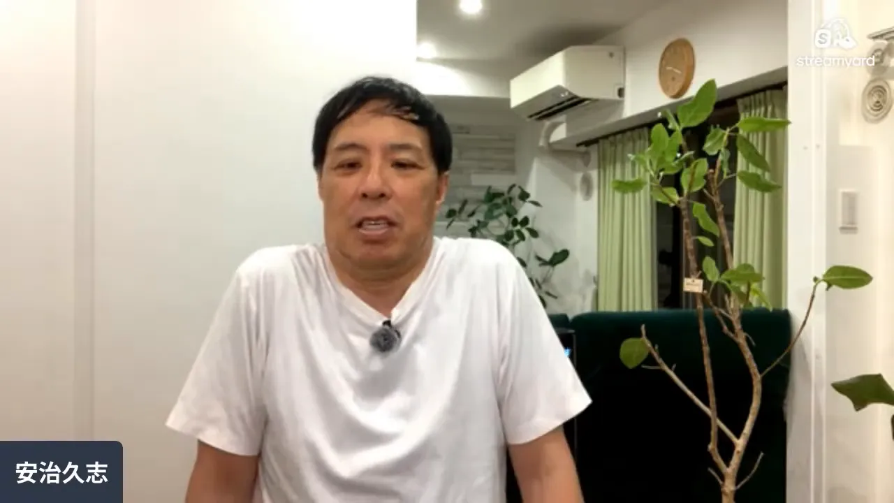座った男性が両肩をすくめて上げている