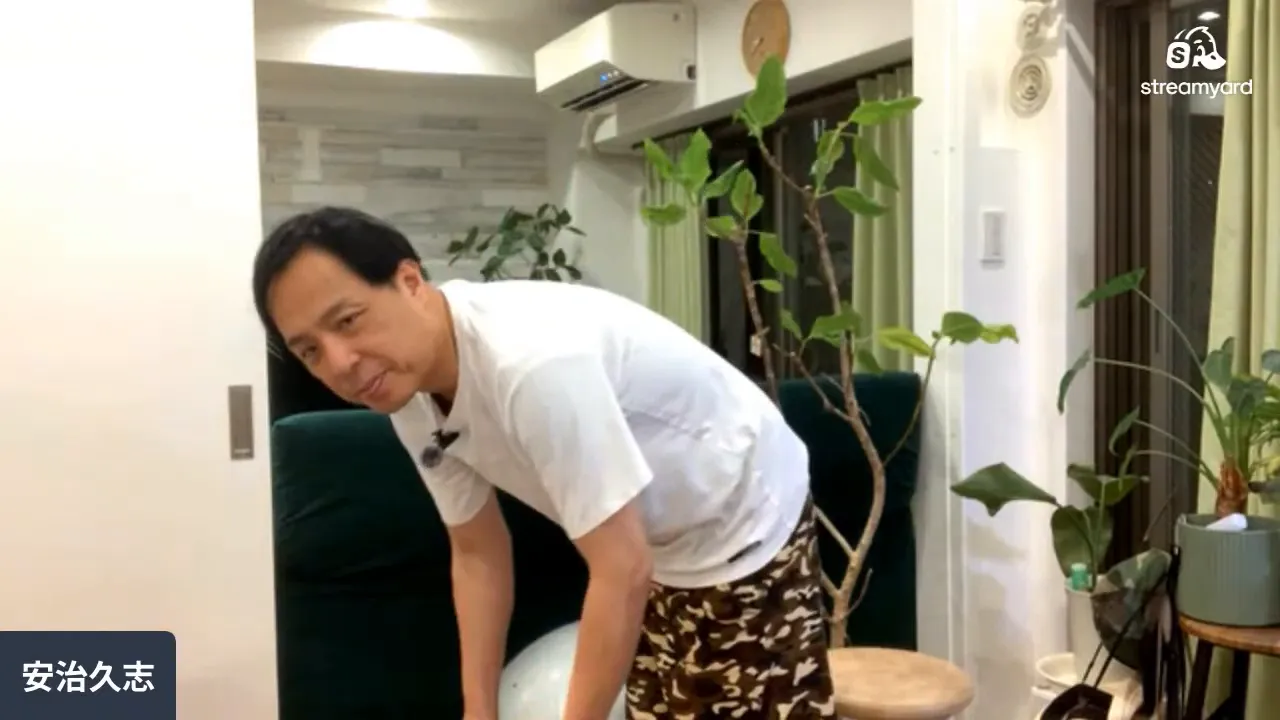 握り拳を作り肩に力を入れたまま前屈する男性