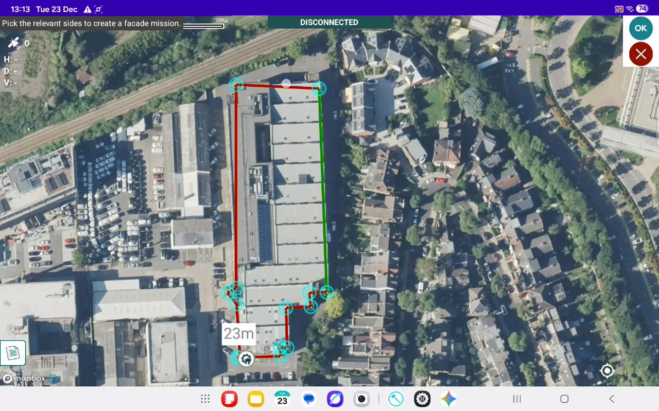 Aerial map view with a building outline; selected façade edges highlighted in red and green with corner nodes visible.