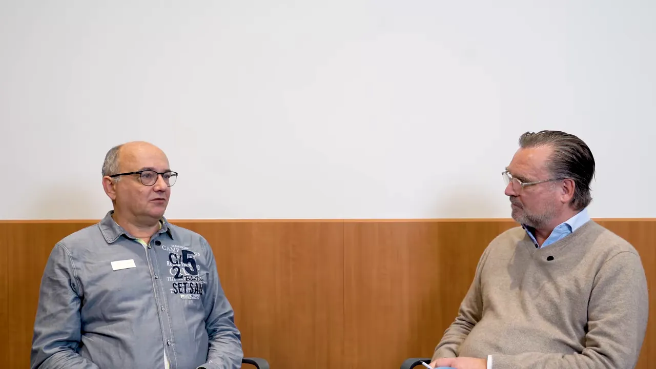 Zwei Gesprächspartner sitzen sich gegenüber und diskutieren in einem Beratungsraum