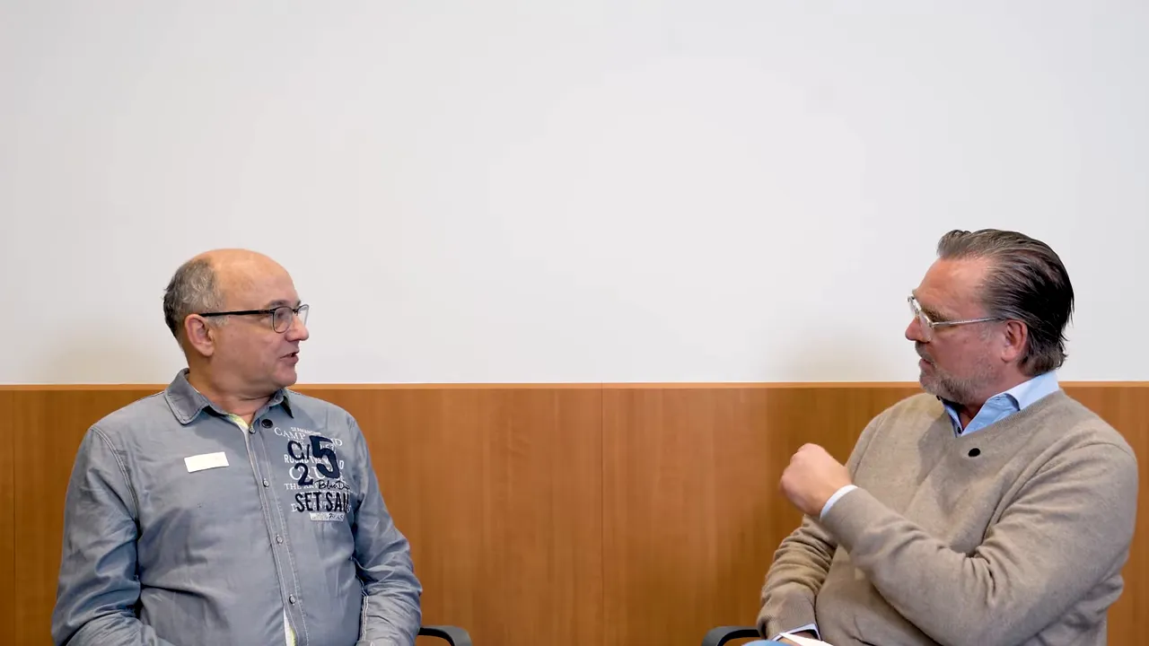 Zwei Männer im Gespräch während eines Interviews, einer gestikuliert