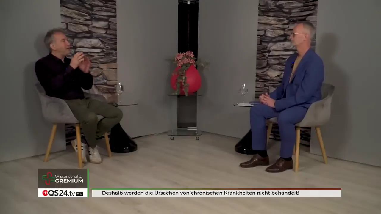 Zwei Interviewpartner in einem Studio mit Hinweistext zu Ursachen chronischer Krankheiten