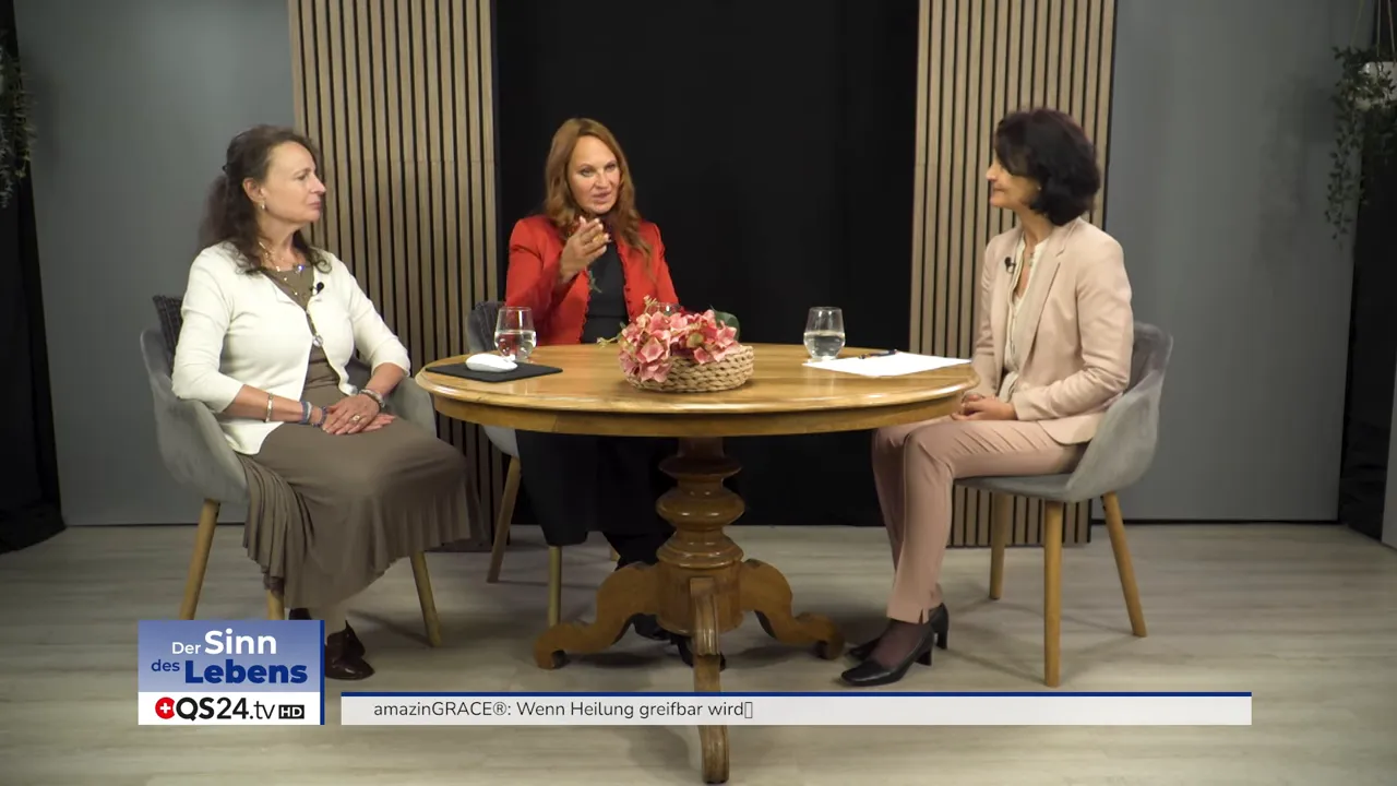 Studioaufnahme: Drei Gesprächspartnerinnen am Tisch, mittlere Person spricht und gestikuliert, Aufnahme klar und gut belichtet.