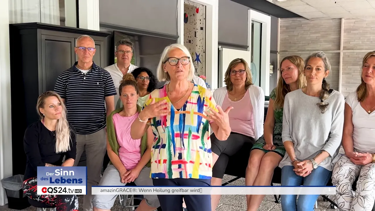 Frau in farbiger Bluse gestikuliert vor einer Gruppe von Zuhörenden; helles, scharfes Gruppenbild mit guter Komposition.