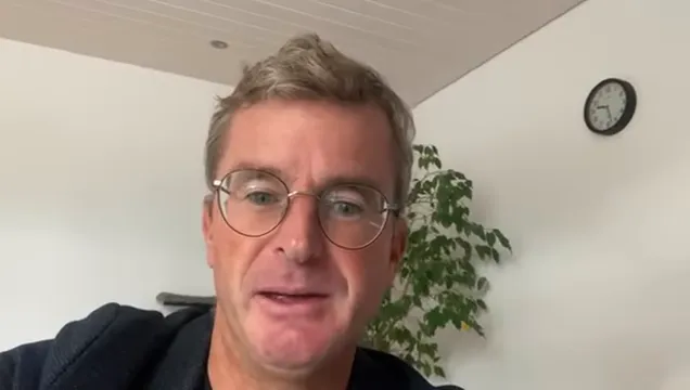 Sprecher im Home-Office erklärt Prinzipien zur Projektbeschleunigung; gut belichtetes Porträt mit Hintergrundpflanze und Uhr