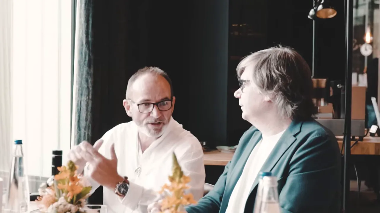 Zwei Männer im Gespräch bei einem Meeting, Austausch über Strategien