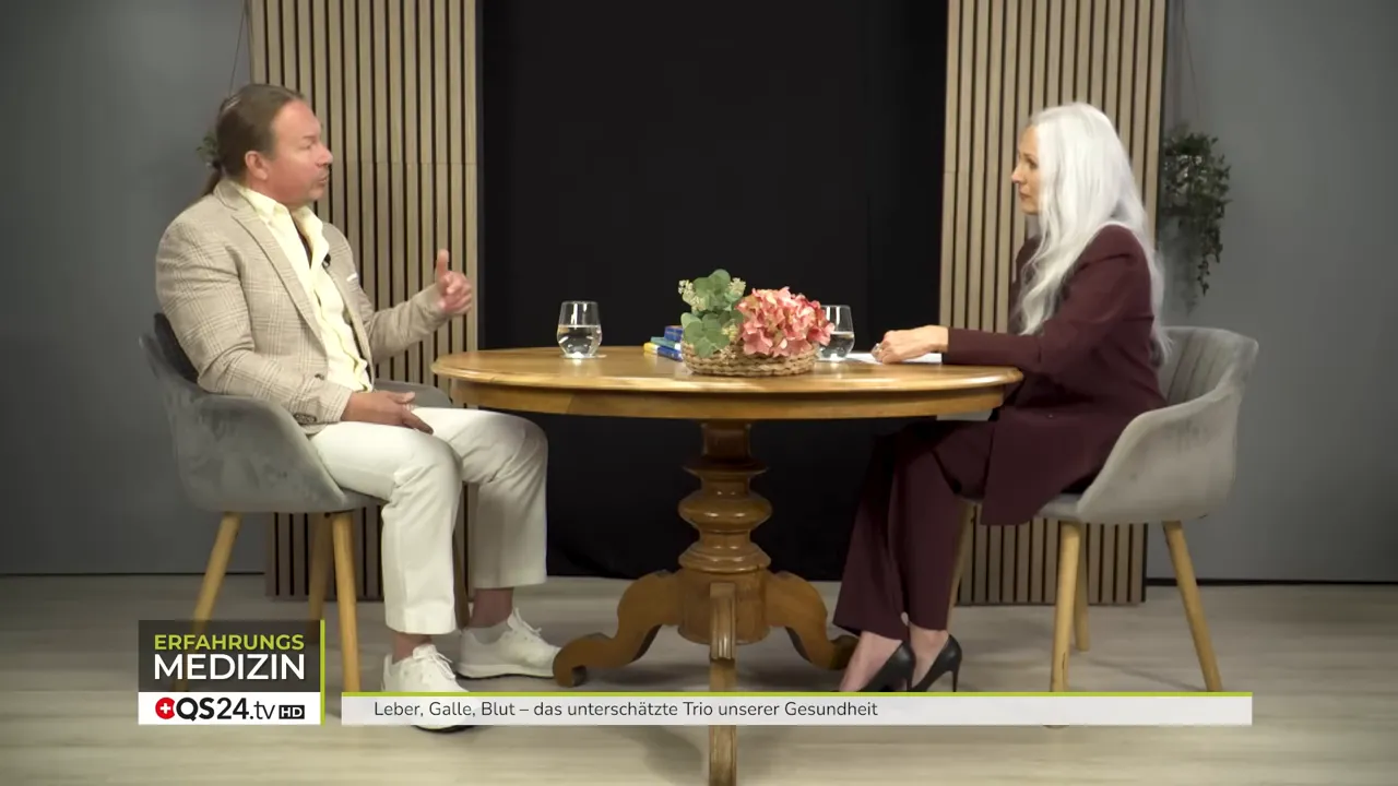 Beide Gesprächspartner an Tisch, Experte gestikuliert und erklärt praktische Maßnahmen