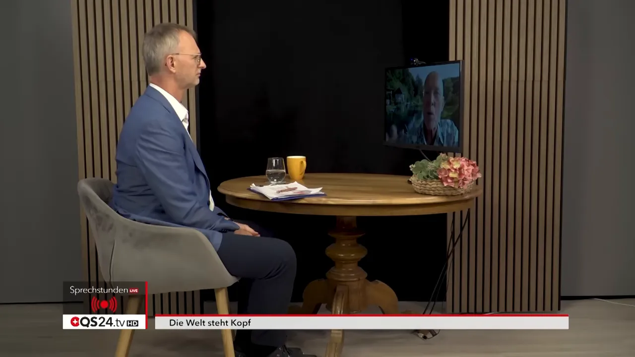 Moderator sitzt im Studio am Tisch, auf einem Monitor ist ein zugeschalteter Experte gut sichtbar