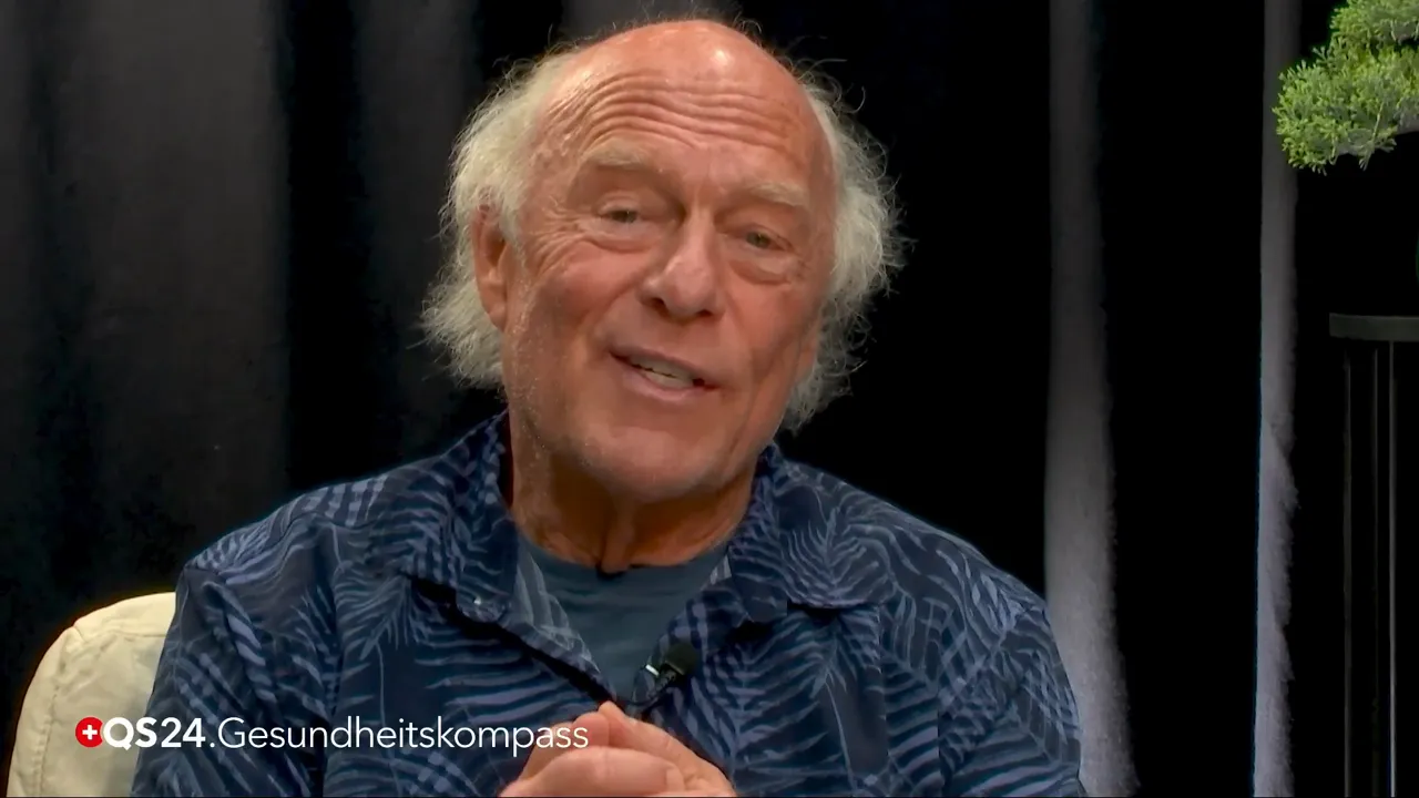 Älterer Mann lächelnd im QS24‑Studio mit sichtbarem 'QS24 Gesundheitskompass' Logo, ruhige, klare Aufnahme.