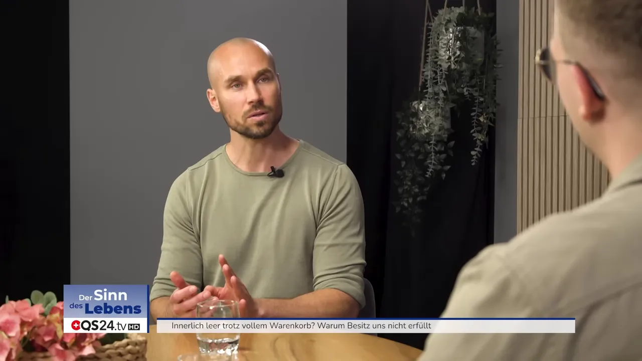 Innerlich leer trotz vollem Warenkorb? Ein Interview mit Stephan Meier, Bewusstseinslehrer 4 Interviewszene: Gesprächspartner gestikuliert am Tisch, Blume und Wasserglas im Vordergrund