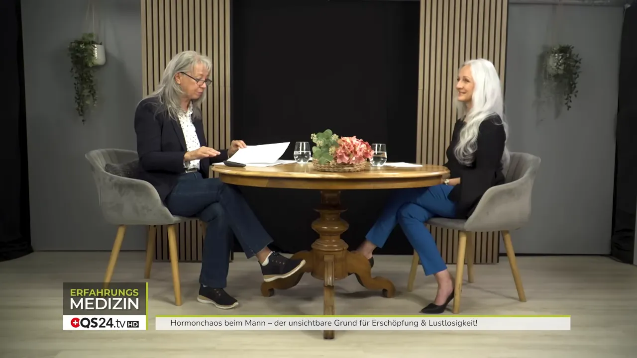 Studioaufnahme: Moderatorin liest Notizen, Expertin lächelt zuhörend – ruhiger Erklärmoment zur Zellerneuerung