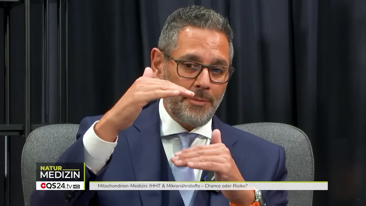 Mann im Anzug erklärt mit zwei parallelen Handflächen das Absinken von Spannung und Energie